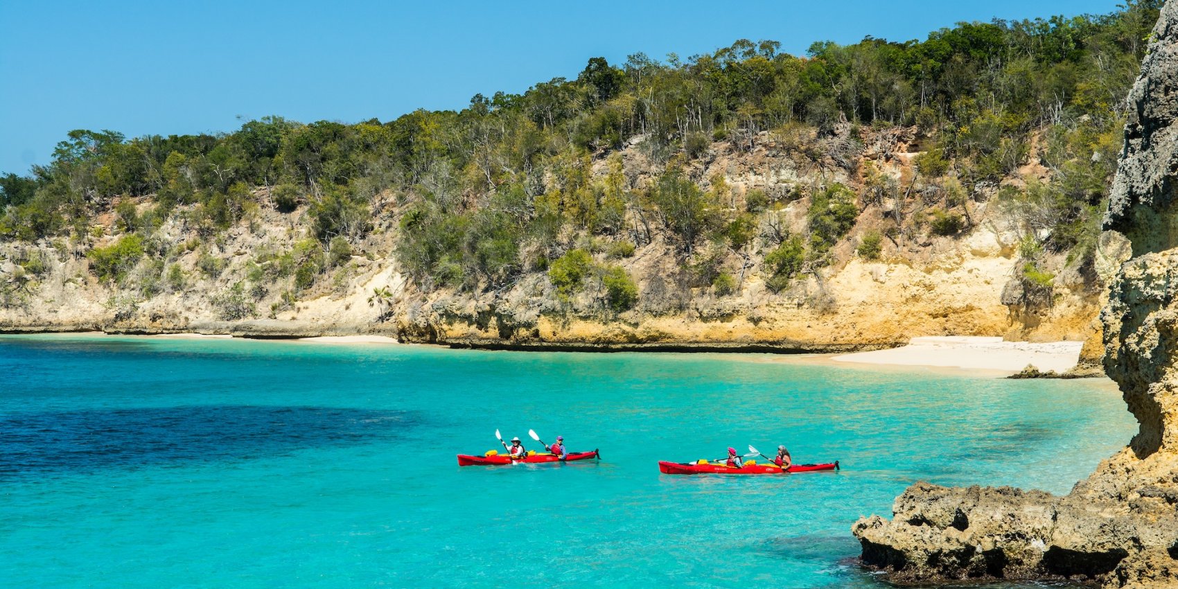 Two sea kayaks off of the coast of Cuba in clear, blue water during a family vacation.