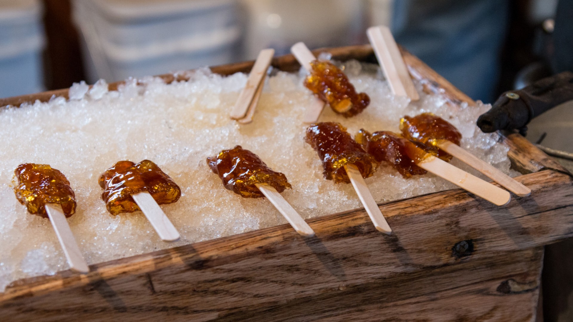 maple syrub taffy on sticks sitting on ice